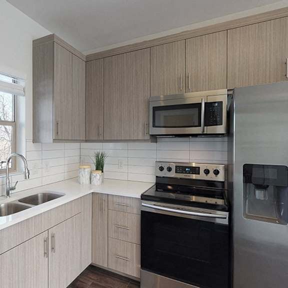 a kitchen with a stove, refrigerator, and sink.