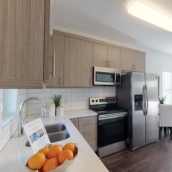 a kitchen with a bowl of oranges on the counter.