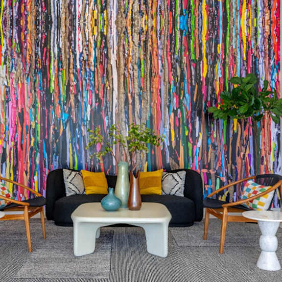 a room with a colorful wallpaper and a black couch.