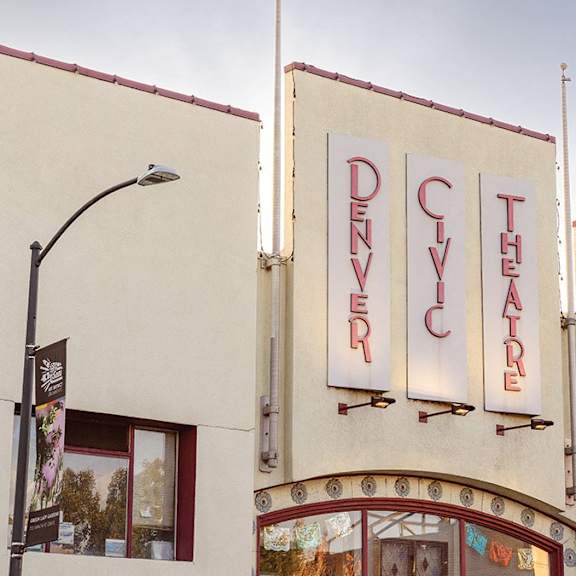 a denver theatre sign is displayed on a building.