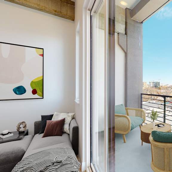 a living room with a grey couch and a view of the city.