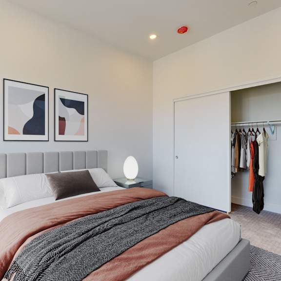 a bedroom with a bed, nightstand, and two framed pictures on the wall.