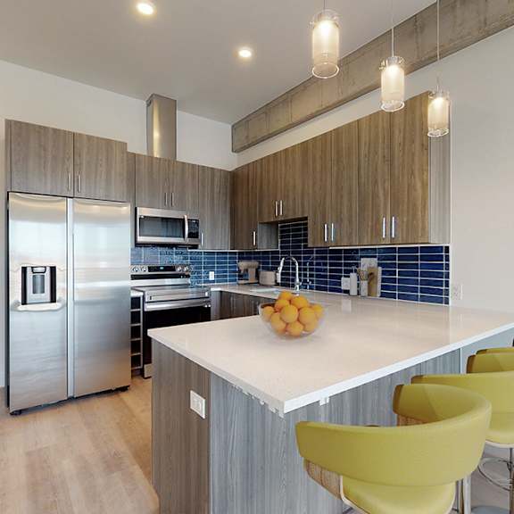 a kitchen with a white counter top and yellow chairs.