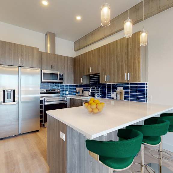a kitchen with a white counter top and green chairs.