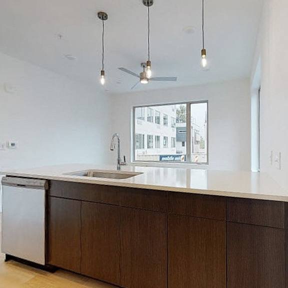a kitchen with a white counter top and a dishwasher.