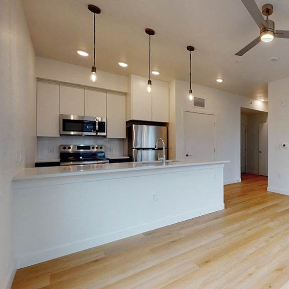 a kitchen with a refrigerator, microwave, and oven.