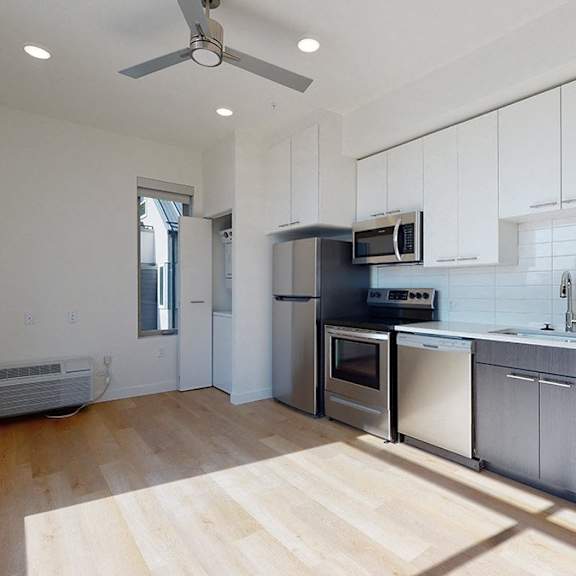 a kitchen with white cabinets and a wooden floor.