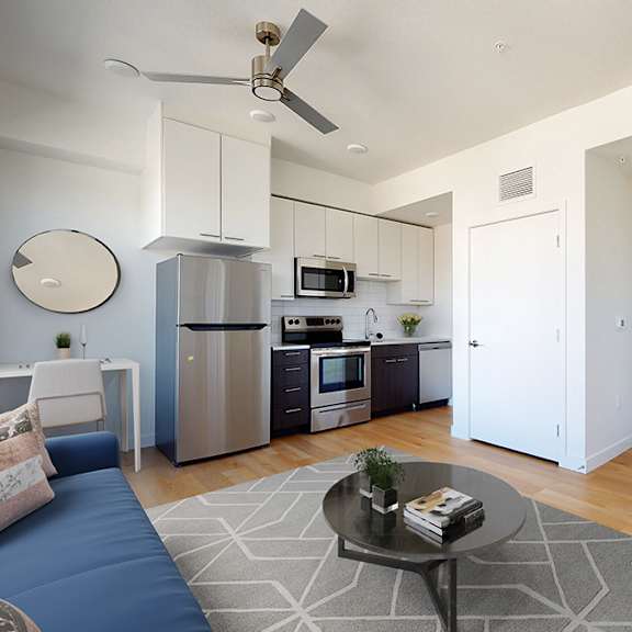 a modern kitchen with a blue sofa and a coffee table.