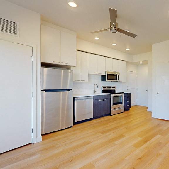 a kitchen with white cabinets and a wooden floor.