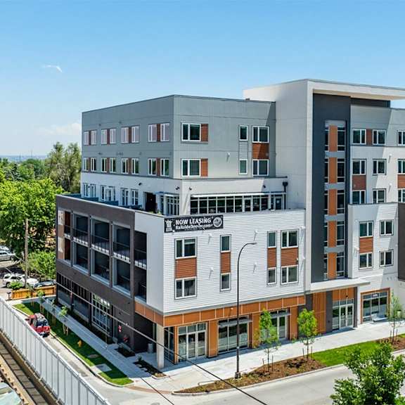 a modern multi-story building with a mix of grey and brown exterior walls.