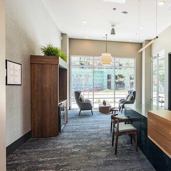 a reception area with a wooden counter and a chair.