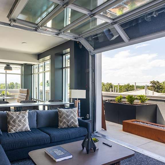 a modern living room with a dark blue sofa and a glass ceiling.