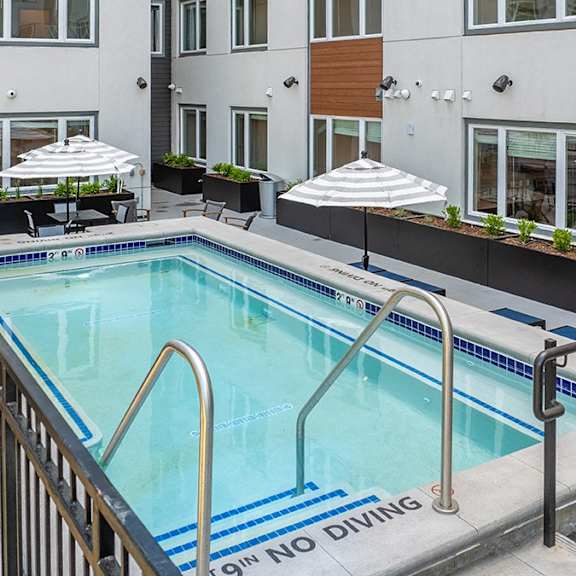 a pool with a diving board and a sign that says