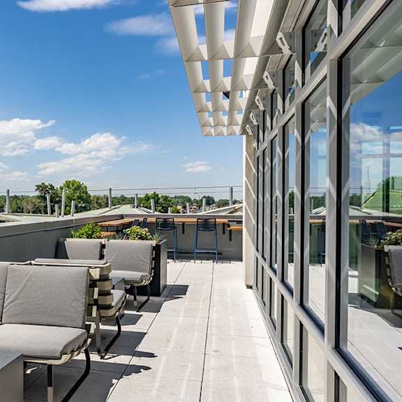 a rooftop patio with a table and chairs.