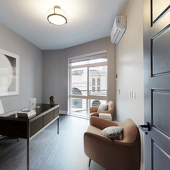 a room with a desk, chair, and a couch.