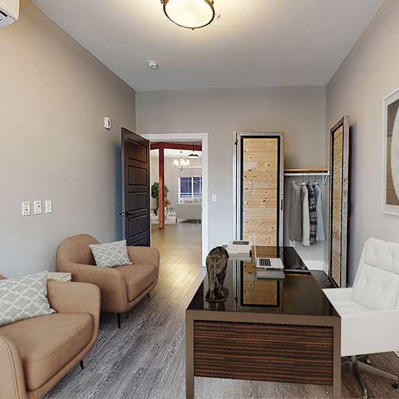 a living room with a brown couch and a white chair.