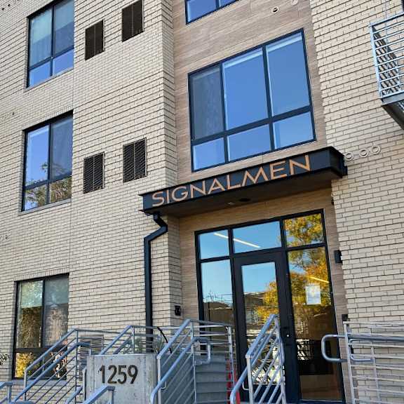 the building is called signalmen and has a black awning.