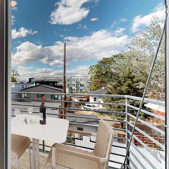 a balcony with a table and chairs overlooking a cityscape.