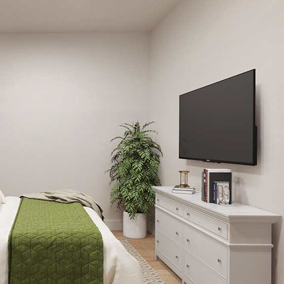 a bedroom with a bed, nightstand, and a plant.