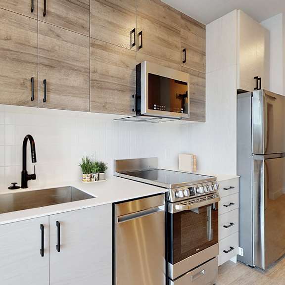 a modern kitchen with white cabinets and a wooden backsplash.
