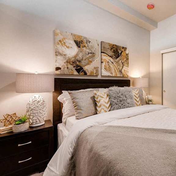 a bedroom with a large bed and a painting on the wall.