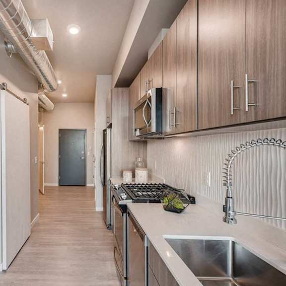 a kitchen with a sink, stove, and cabinets.