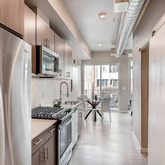 a modern kitchen with stainless steel appliances and wooden cabinets.