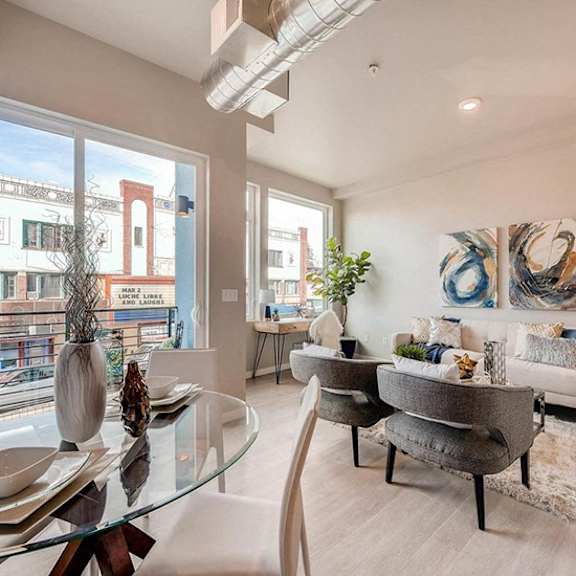 a modern living room with a glass table and chairs.