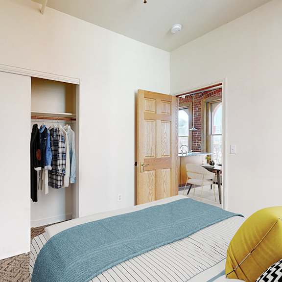 a bedroom with a bed, a chair, and a wardrobe.