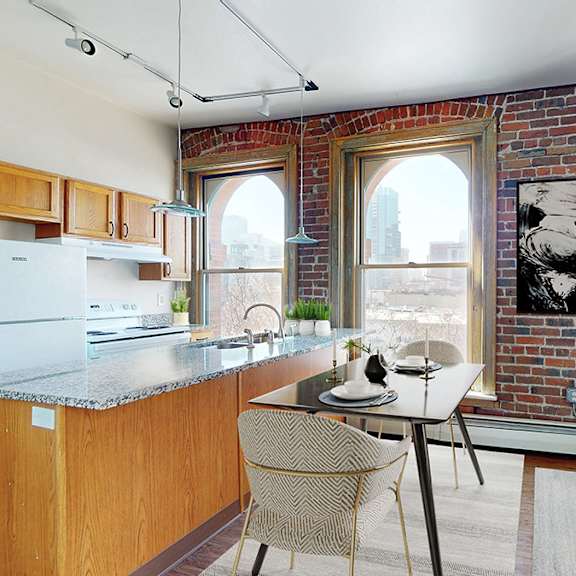 open-plan kitchen with island,  dining table and living area with sofa. 3 large floor-to-ceiling windows look out on to the city landscape.