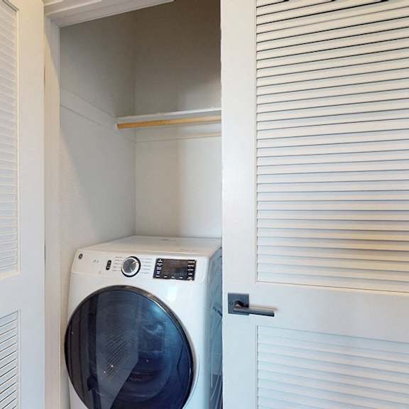 a washing machine is built into a wall in a laundry room.