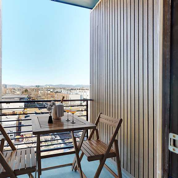 a balcony with a table and two chairs overlooking a marina.