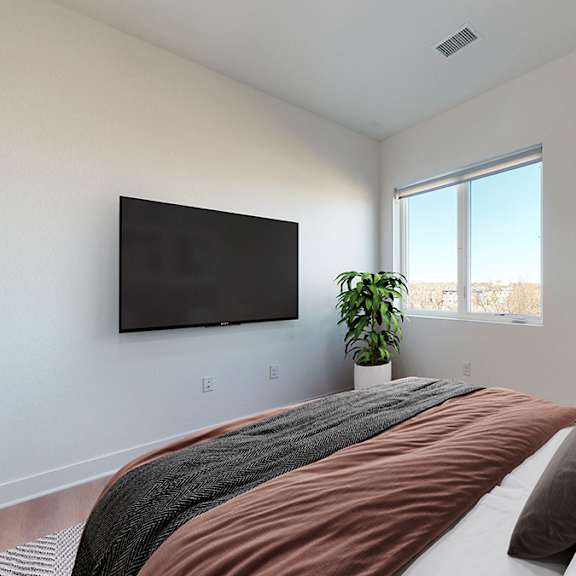 a bedroom with a large bed and a flat screen tv mounted on the wall.