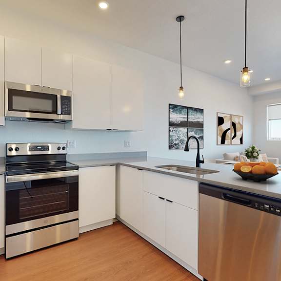 a modern kitchen with stainless steel appliances and white cabinets.