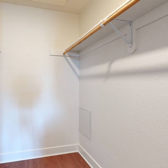 a white wall with a brown shelf and a white pipe.