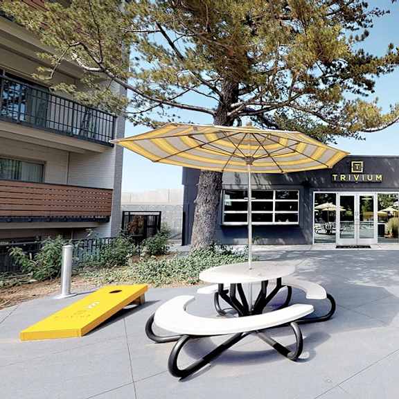 a modern building with a yellow umbrella-like structure in front.