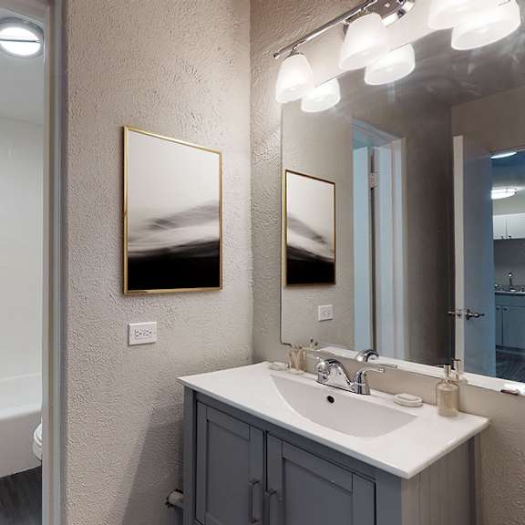 a bathroom with a white sink and a mirror.