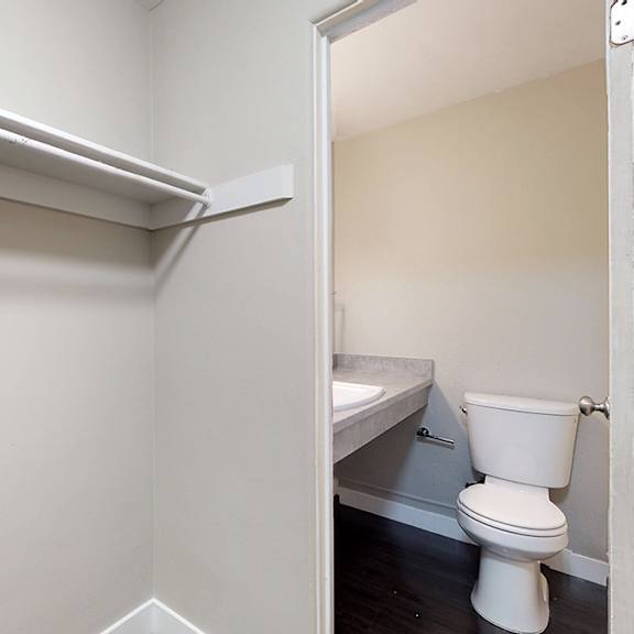 a white toilet sits in a small bathroom.