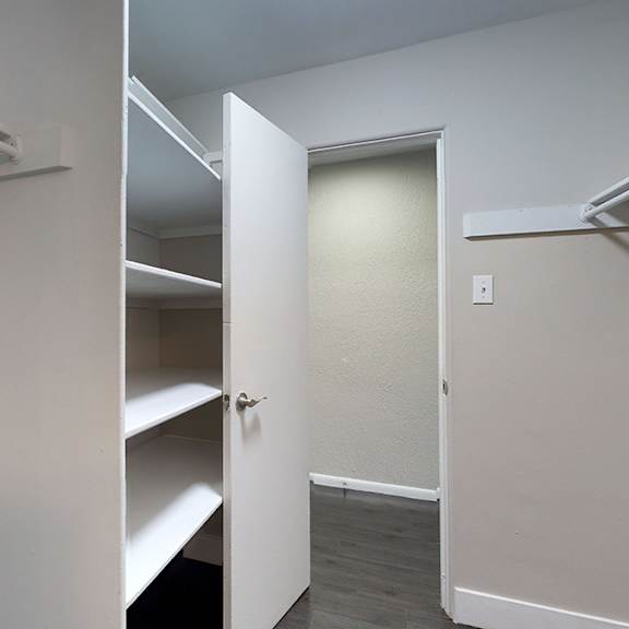 a white door is open to a hallway with bunk beds on the left.