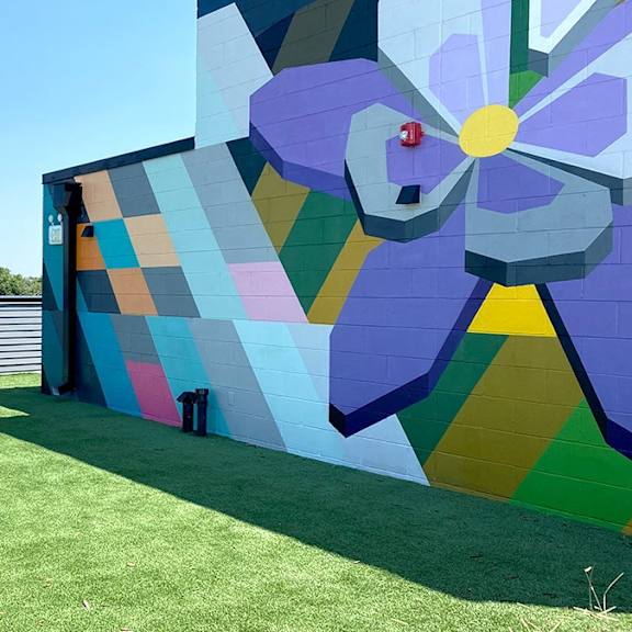 a large mural of a flower is painted on a wall.
