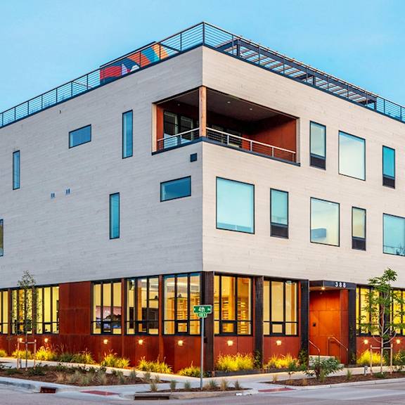 a modern building with a balcony on the top floor.