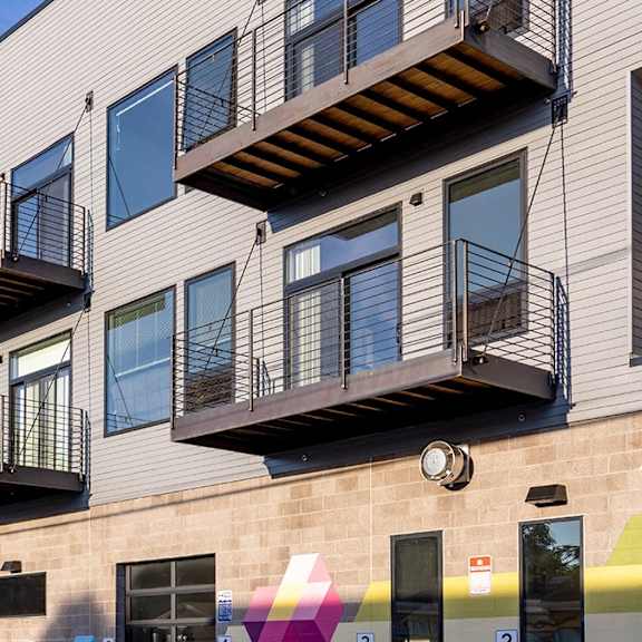 a building with balconies and a wall with a colorful design.