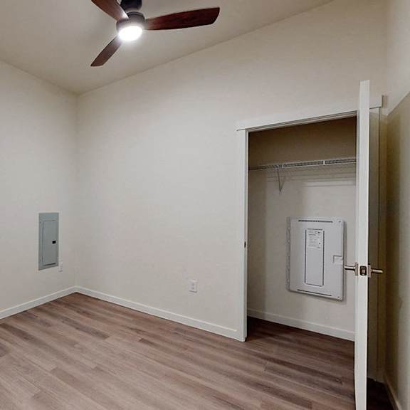 a room with a ceiling fan and a window.