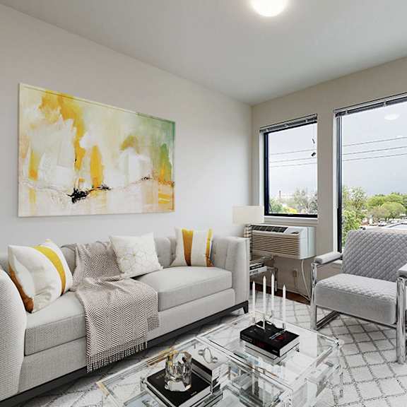a living room with a grey couch and a painting on the wall.