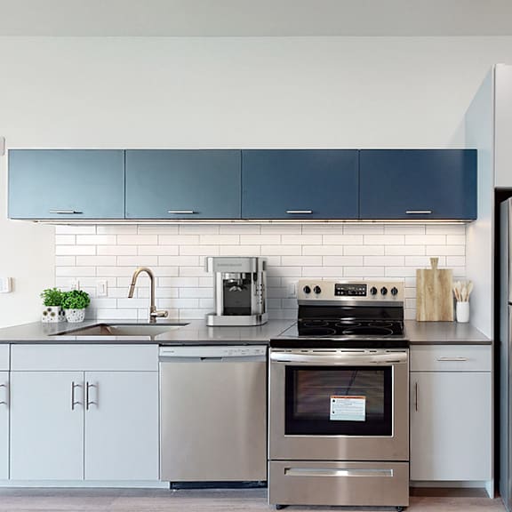 a modern kitchen with stainless steel appliances and white cabinets.