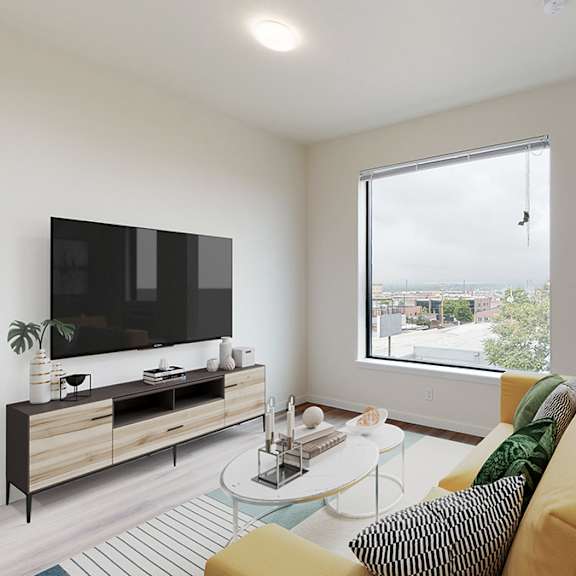 a living room with a yellow couch and a television.