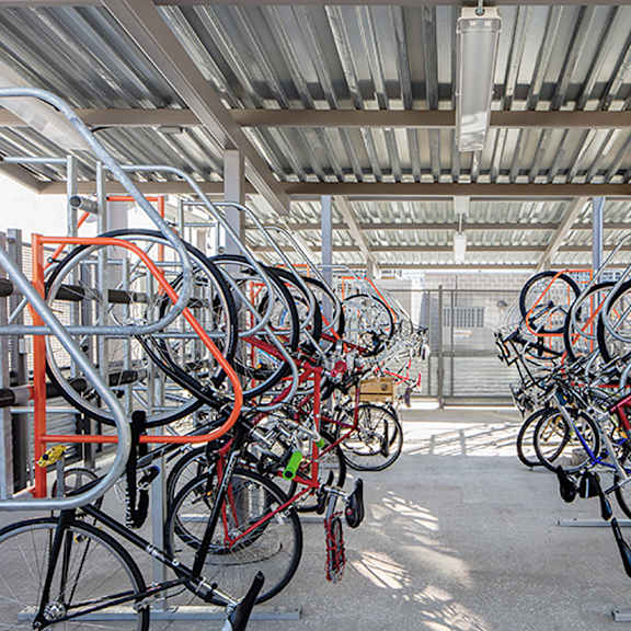 a bike rack full of bicycles in a parking area.