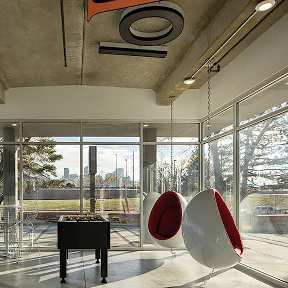 a room with a piano and two egg-shaped chairs.