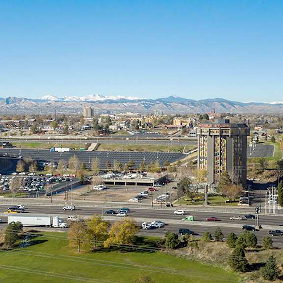 a cityscape with a large stadium and mountains in the background.