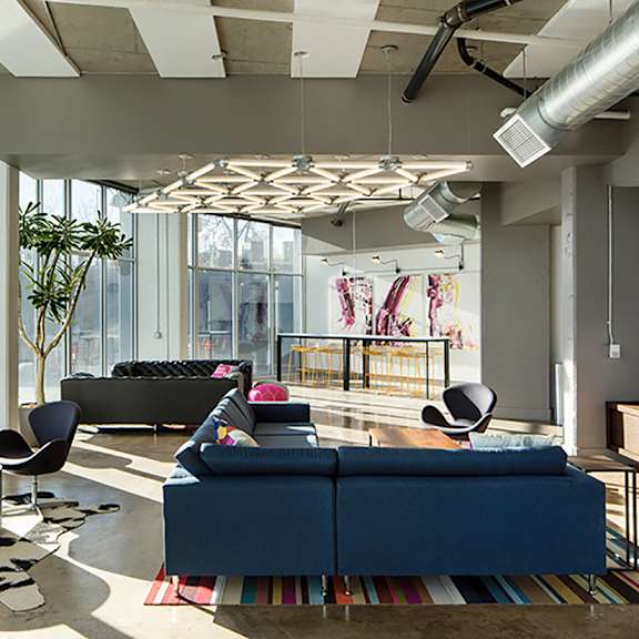 a modern living room with a blue couch and a tv on the wall.